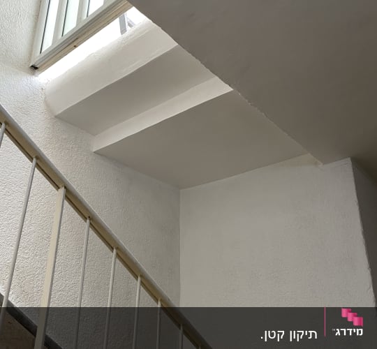 מדרגות עם מעקה וחלון פתוח בקיר